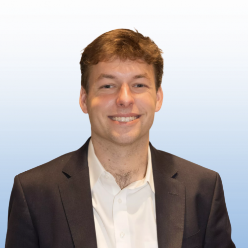Professional headshot of a smiling Equity team member with reddish-brown hair wearing a dark blazer and white shirt.