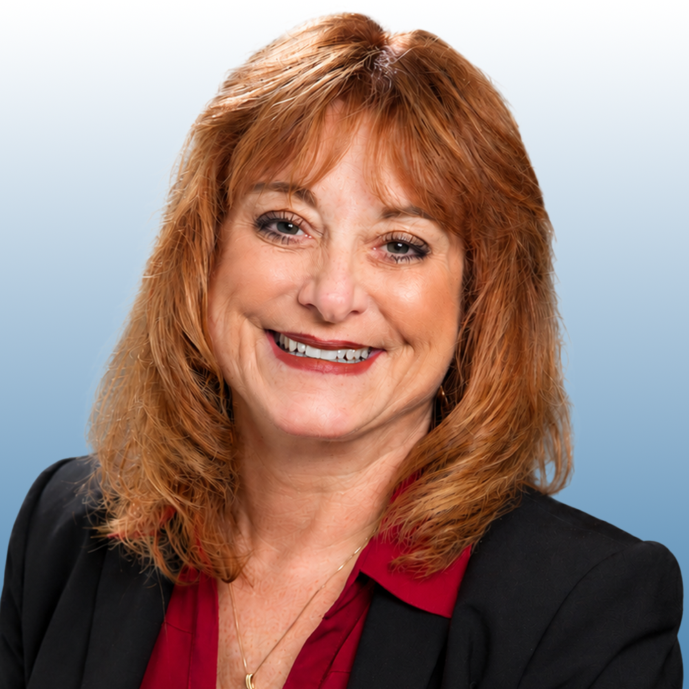 Professional headshot of a smiling Equity team member with auburn hair